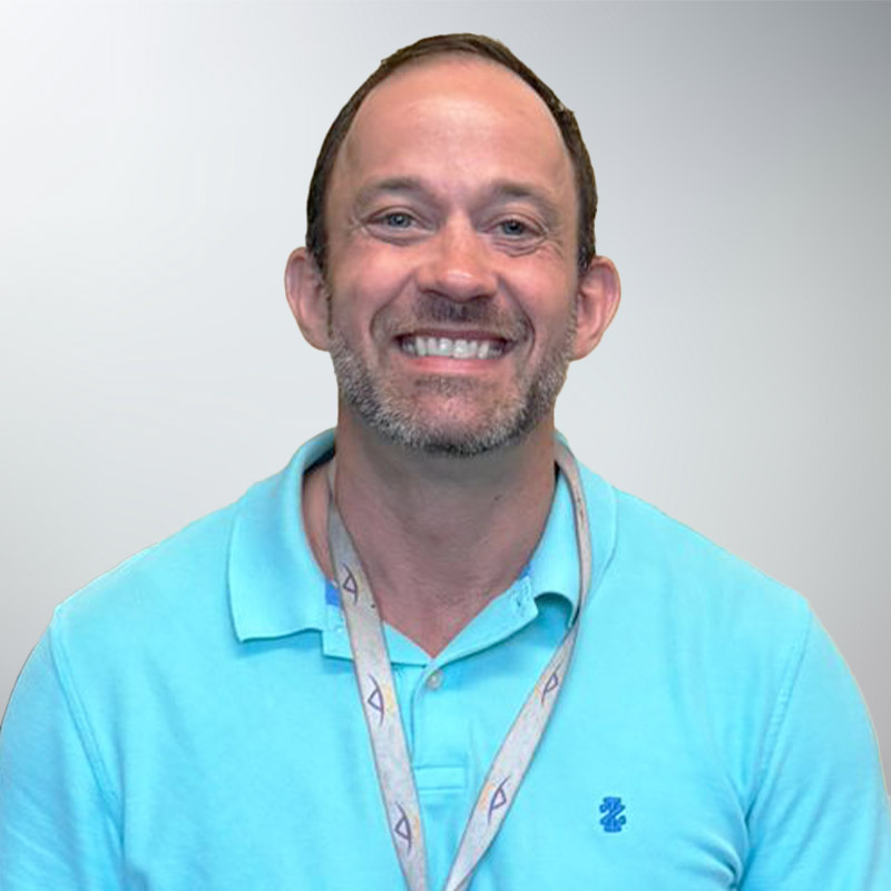 a man wearing a blue shirt and smiling at the camera
