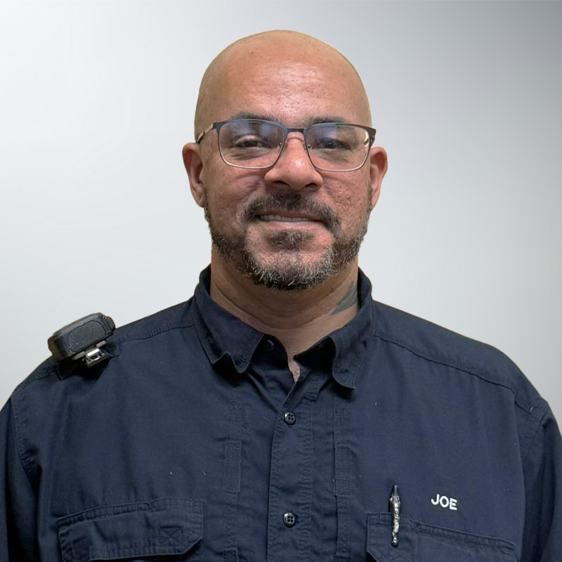 a man wearing glasses and smiling at the camera