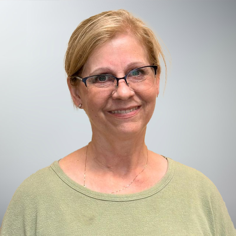 a person wearing glasses and smiling at the camera