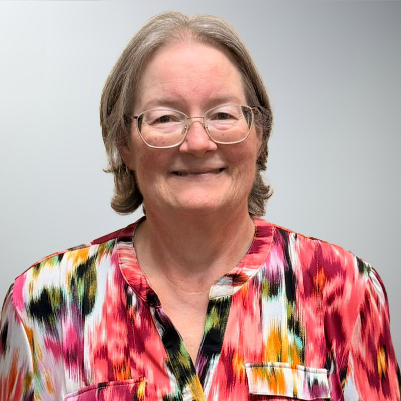 a person wearing glasses and smiling at the camera